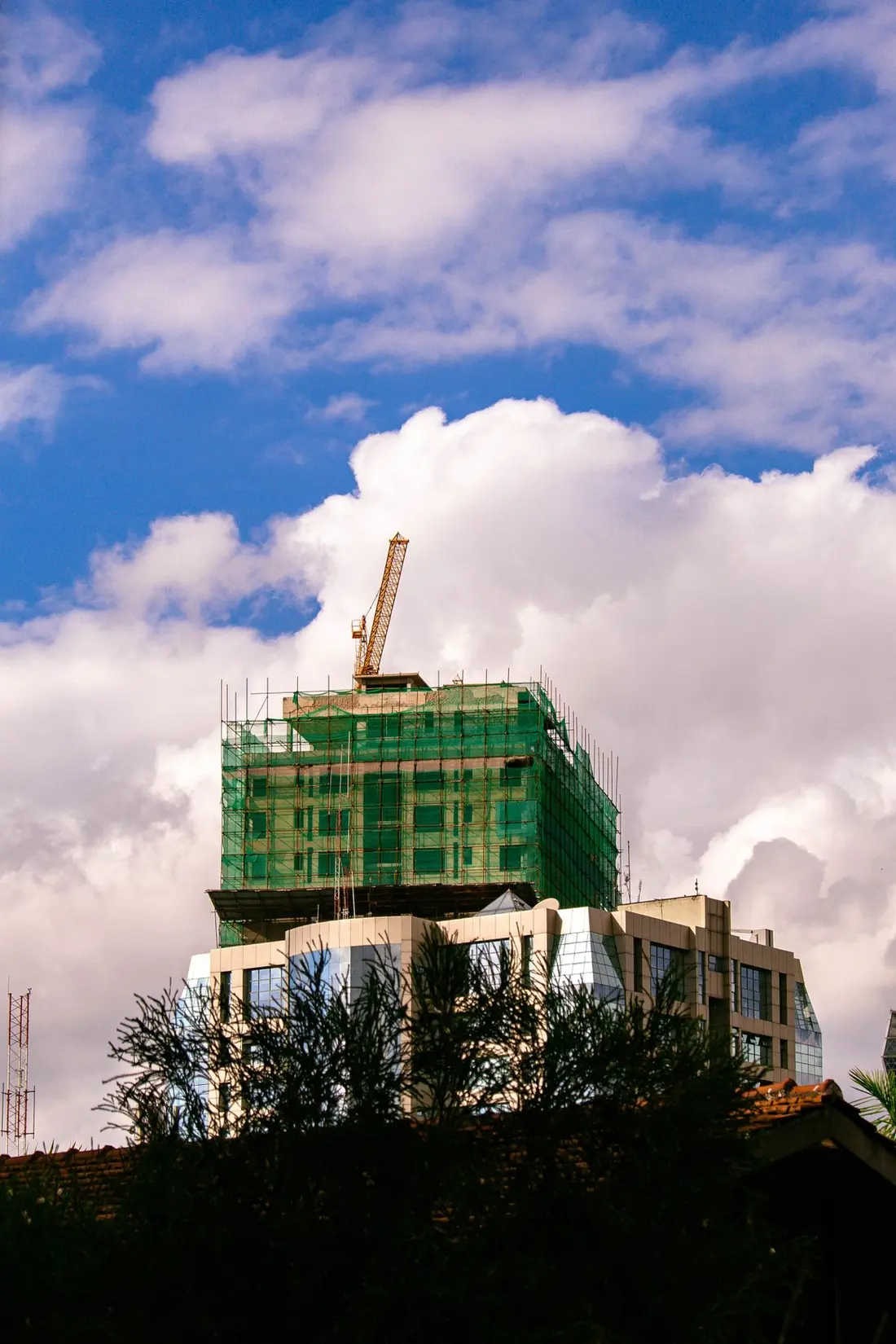 A high-rise development under construction in Nairobi with a tower crane against a clear sky.